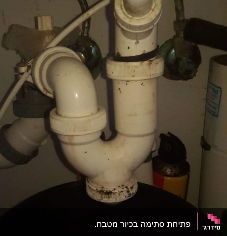 צינור ביוב לבן עם חיבורים מתחת לכיור